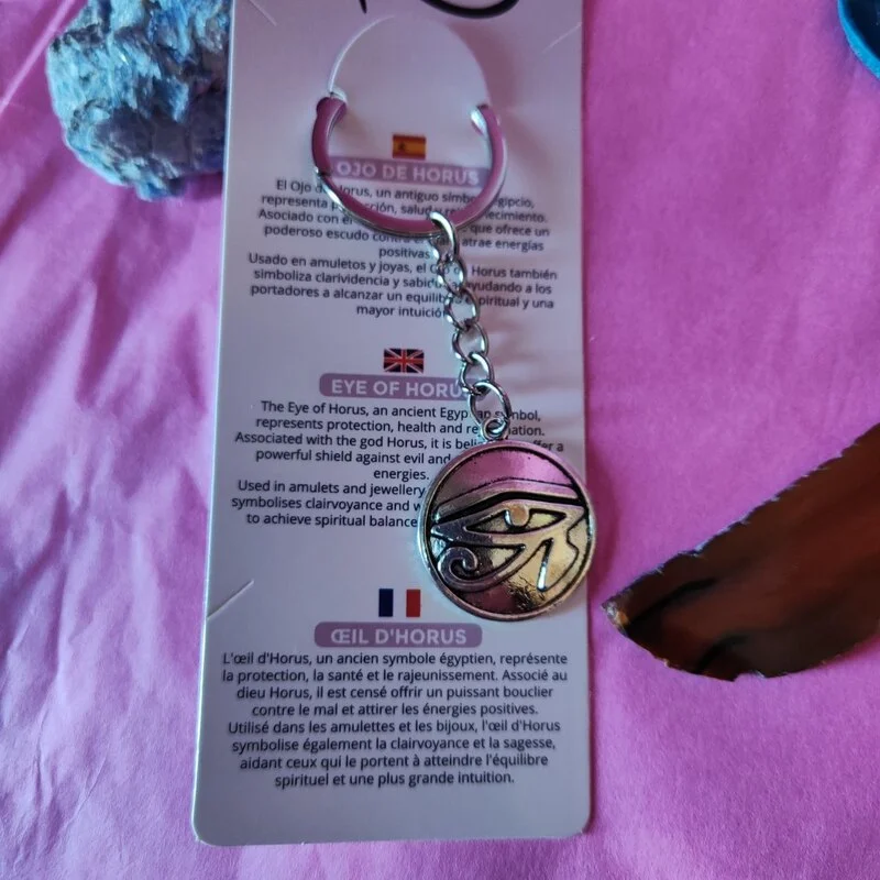 LLAVERO DE BISUTERÍA DE METAL CON CARTULINA EN 6 IDIOMAS EN FORMA DE OJO DE HORUS 27 MM