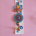 CHARM DE MADERA CON CAMPANA Y OJO TURCO ELEFANTE 28 X 8 CM